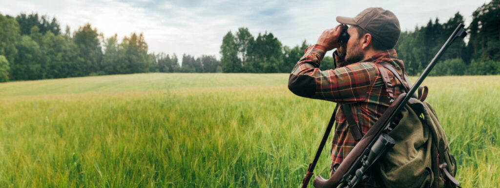 best hunting binoculars - Man using hunting binoculars